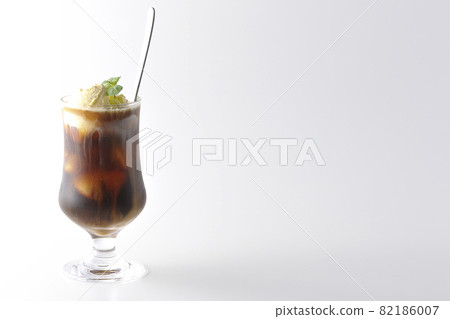拍攝的咖啡漂浮物,香草冰淇淋在白色背景上融化 拍攝的咖啡漂浮物,香草冰淇淋在白色背景上融化 82186007