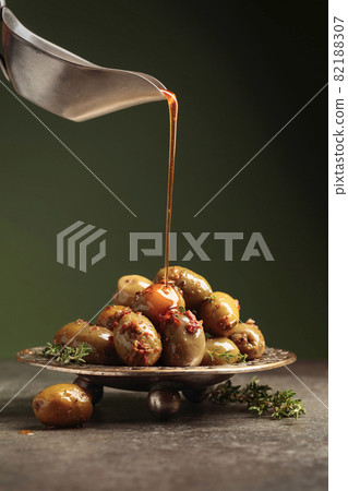 Spicy green olives are poured with olive oil with spices. 82188307