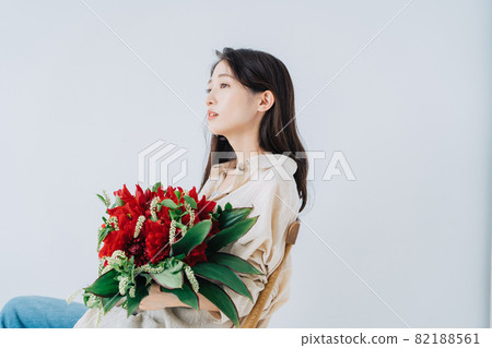 Young woman with a bouquet Young woman with a bouquet 82188561