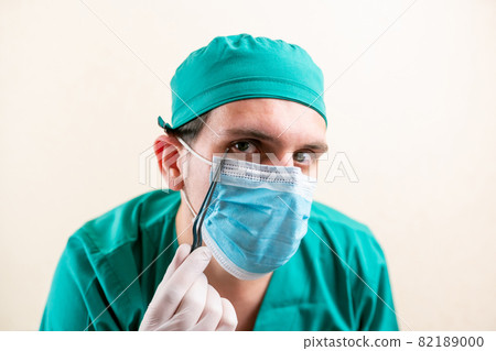 Doctor ENT, wearing a mask and glasses, with a device in his hands. 82189000