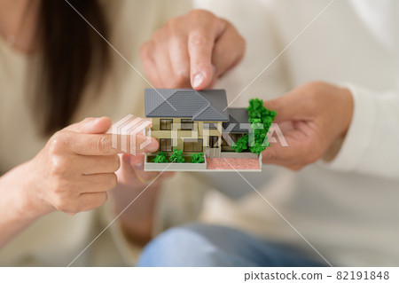 Senior couple with a house model at hand 82191848