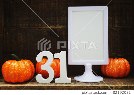 Blank Display frame stand with number 31 and orange pumpkin on wooden background Blank Display frame stand with number 31 and orange pumpkin on wooden background 82192081