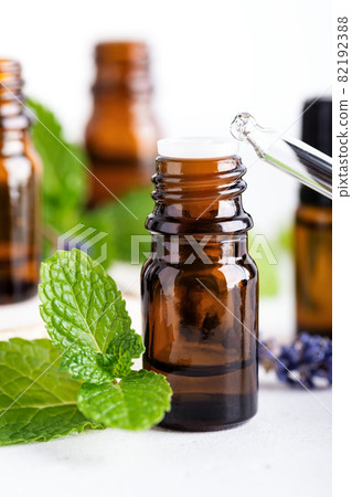 Essential oil in dark amber bottle and glass dropper closeup Essential oil in dark amber bottle and glass dropper closeup 82192388