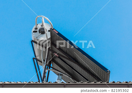 Solar panel energy and modern water heating technologies collector system on the roof of the building against the background of blue sky Solar panel energy and modern water heating technologies collector system on the roof of the building against the background of blue sky 82195302
