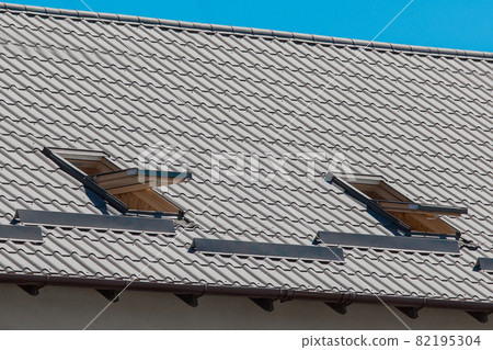 Modern design of the roof of the house with open windows architecture against the blue sky Modern design of the roof of the house with open windows architecture against the blue sky 82195304