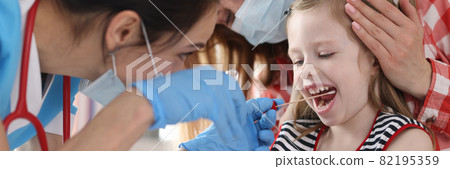 Doctor in protective medical mask taking buccal swab from little girl with cotton swab Doctor in protective medical mask taking buccal swab from little girl with cotton swab 82195359