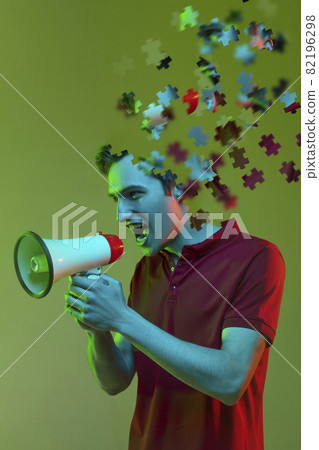 Modern collage of caucasian boy shouting in megaphone isolated over green background. Male head consist of puzzle pieces. Modern collage of caucasian boy shouting in megaphone isolated over green background. Male head consist of puzzle pieces. 82196298