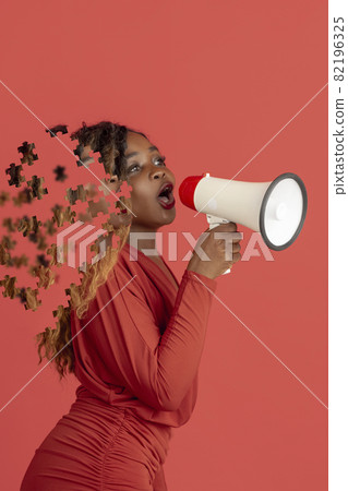 Creative collage of young african woman talking in megaphone. Female head consist of puzzle pieces 82196325