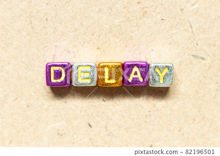 Metallic color alphabet letter block in word delay on wood background Metallic color alphabet letter block in word delay on wood background 82196501