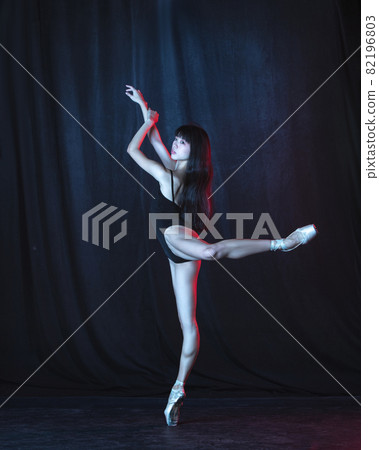 Young and graceful female ballet dancer in motion isolated on dark background in neon light. Art, motion, action, flexibility, inspiration concept. Young and graceful female ballet dancer in motion isolated on dark background in neon light. Art, motion, action, flexibility, inspiration concept. 82196803