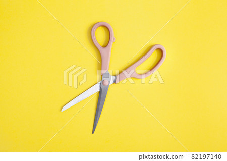 open pink scissors isolated on yellow background open pink scissors isolated on yellow background 82197140