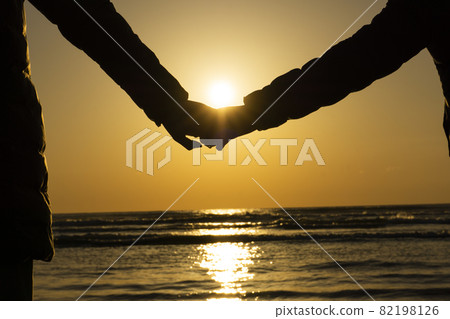 父母和孩子手牽手在沙灘上看日落 82198126