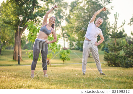A mature couple exercising in the park A mature couple exercising in the park 82199212