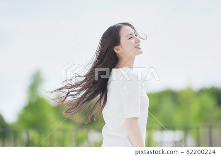 A woman with her hair fluttering outdoors 82200224