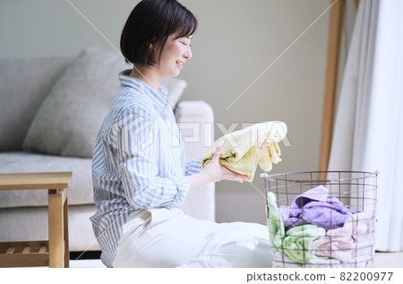 A woman folding laundry A woman folding laundry 82200977