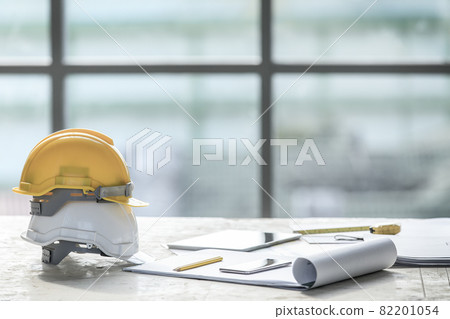 White and yellow safety helmet in construction site 82201054