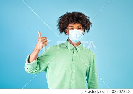 African american guy in protective face mask showing thumb up, support social-distancing during coronavirus pandemic African american guy in protective face mask showing thumb up, support social-distancing during coronavirus pandemic 82202890