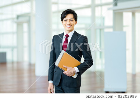 一個穿著西裝的年輕商人在辦公室工作 一個穿著西裝的年輕商人在辦公室工作 82202989
