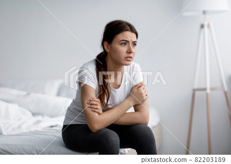 Sad anxiety young attractive caucasian woman suffering from mental problems, stress and insomnia sitting on bed 82203189