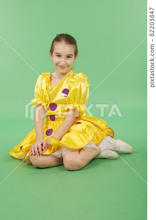 Pretty girl posing for the camera, in a yellow short dress. Pretty girl posing for the camera, in a yellow short dress. 82203847