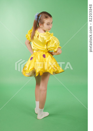 Pretty girl posing for the camera, in a yellow short dress. Pretty girl posing for the camera, in a yellow short dress. 82203848