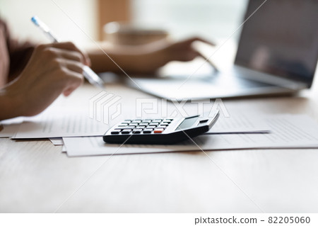 Closeup of female bookkeeper work at desk on calculator laptop 82205060