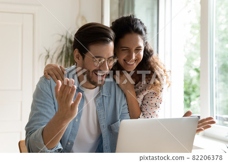 Happy couple reading great unbelievable amazing news on laptop 82206378