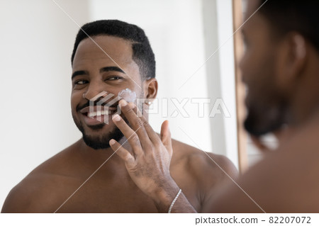 African guy applying cleanse products or facial cream on face African guy applying cleanse products or facial cream on face 82207072