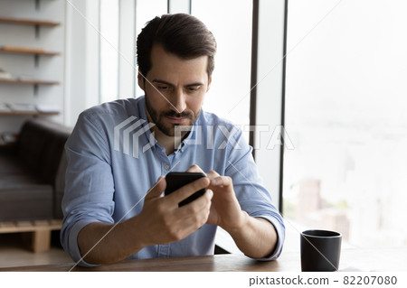 Serious man use smartphone gadget texting online Serious man use smartphone gadget texting online 82207080