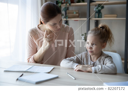 Unhappy young mother scolding small kid for bad marks. 82207172