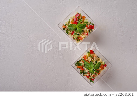 Flat lay tabbouleh salad. Traditional Middle Eastern dish with parsley, mint, bulgur, tomatoes in Flat lay tabbouleh salad. Traditional Middle Eastern dish with parsley, mint, bulgur, tomatoes in 82208101