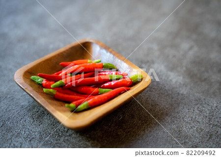 在一個木碗的紅辣椒在黑暗的背景 82209492