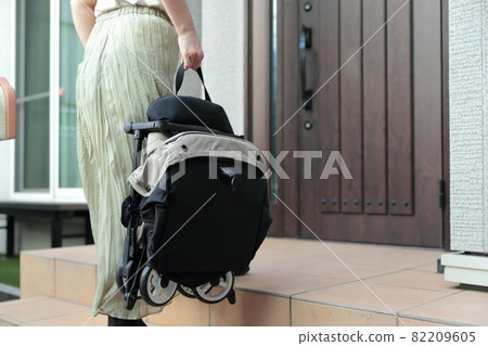 舉起嬰兒車回家的家庭主婦 82209605