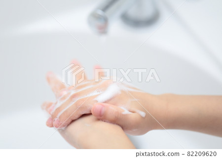 用洗手液在洗手盆上洗手的女孩 用洗手液在洗手盆上洗手的女孩 82209620