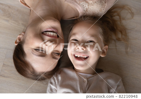 Happy young mother lying on floor with small kid. Happy young mother lying on floor with small kid. 82210948