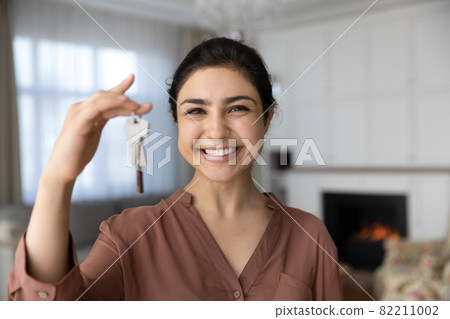 Excited indian female become homeowner look at camera hold key Excited indian female become homeowner look at camera hold key 82211002