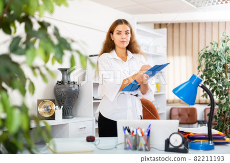 Confident young secretary takes important notes on a tablet in a office Confident young secretary takes important notes on a tablet in a office 82211193