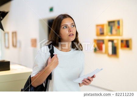 Thoughtful young girl in an art gallery studies works of art 82211220