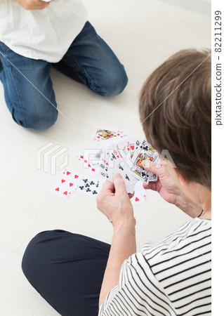 Grandmother and children playing cards 82211299
