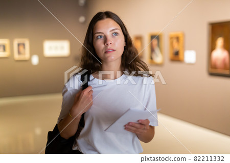 Focused girl visitor, admirins the paintings in the museum 82211332