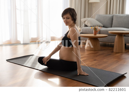 Healthy active female waiting for baby carry out gymnastic exercises 82211601