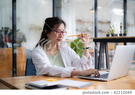 Young undergraduate student studying online class by laptop computer. 82212049