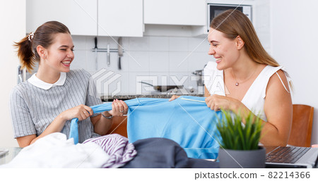 Emotinal women holding blue jacket and having conflict about sharing 82214366