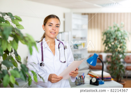 Female doctor standing in hall of clinic Female doctor standing in hall of clinic 82214367