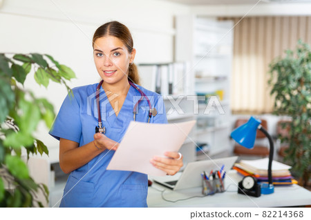 Female doctor standing in hall of clinic Female doctor standing in hall of clinic 82214368