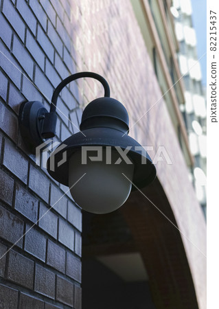 An outdoor light on the outer wall of an urban condominium 82215437