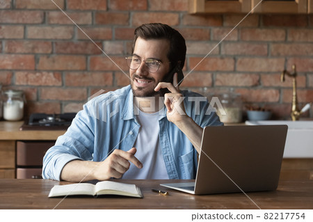 Smiling man in glasses talking on phone, consulting client 82217754