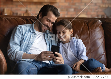 Happy father and little son having fun with smartphone Happy father and little son having fun with smartphone 82217765