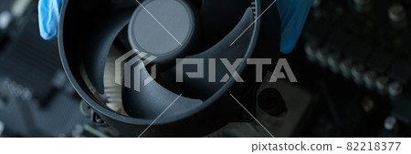 Gloved craftsman installing cooler into video card closeup 82218377