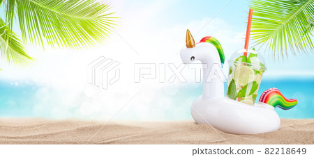 Fresh cold mojito cocktail in inflatable unicorn toy on tropical beach Fresh cold mojito cocktail in inflatable unicorn toy on tropical beach 82218649